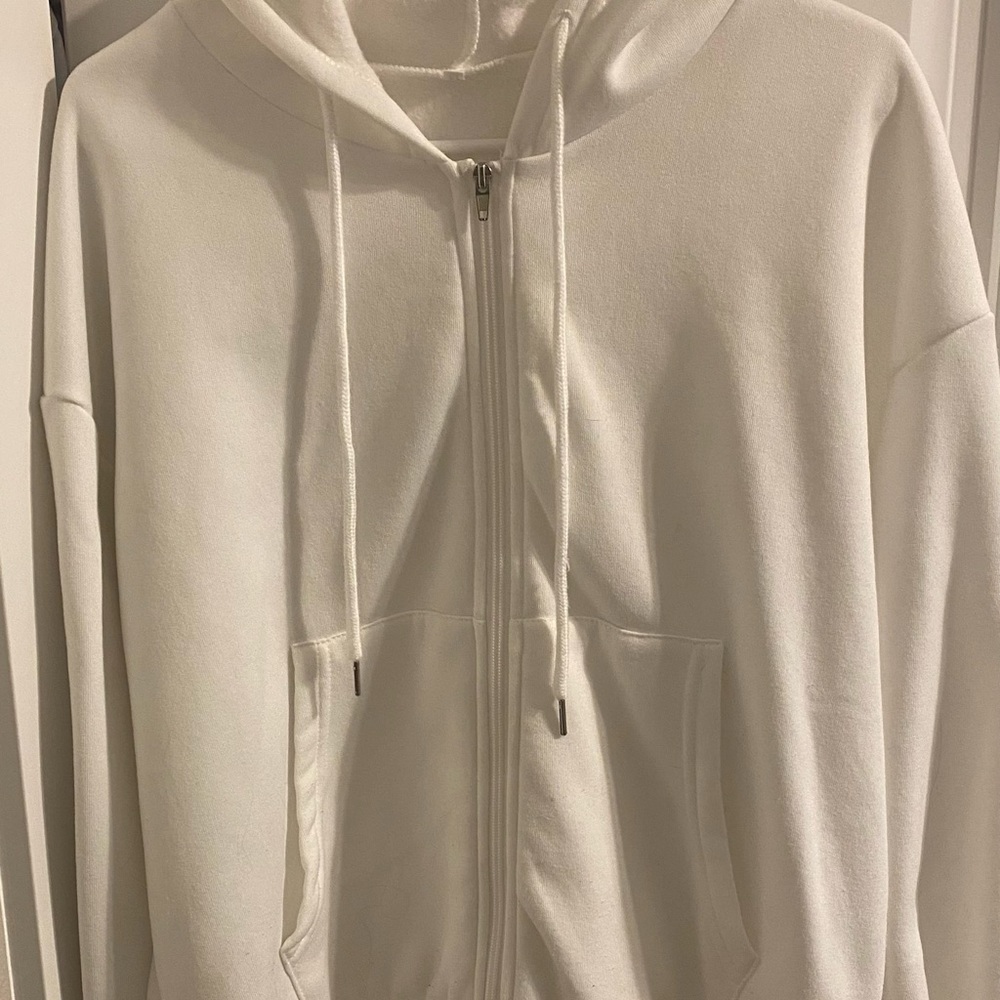 Three zip up hoodies black white and brown